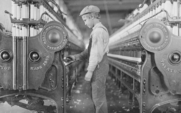 foto van een kind aan het werk in een katoenfabriek in 1908